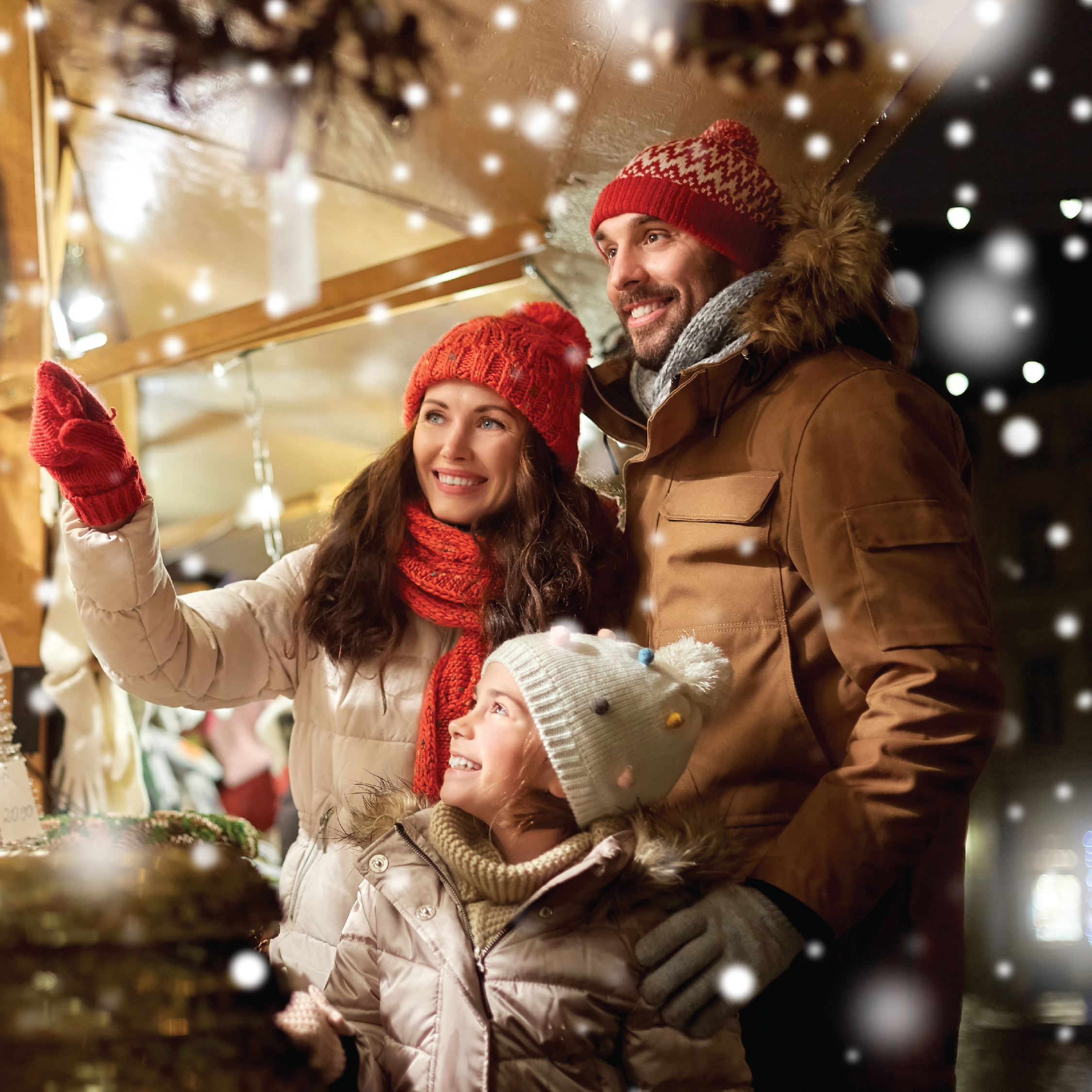 Family of 3 looking at christmas lights